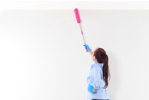 Femme nettoyant un plafond