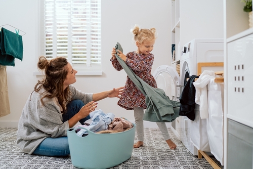 femme et petite fille vidant une machine à laver