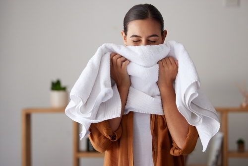Femme qui sent un linge blanc propre