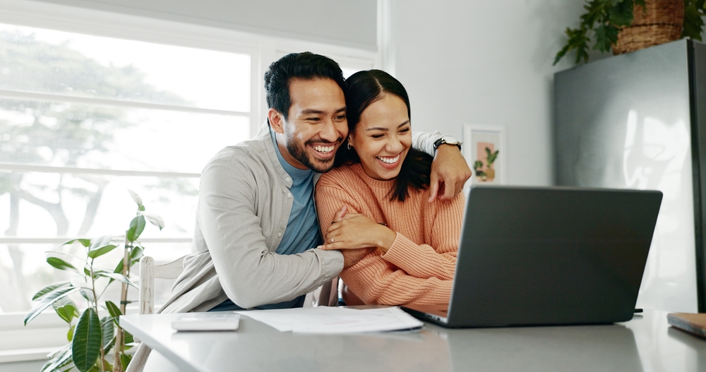 couple heureux effectuant des démarches sur leur ordinateur